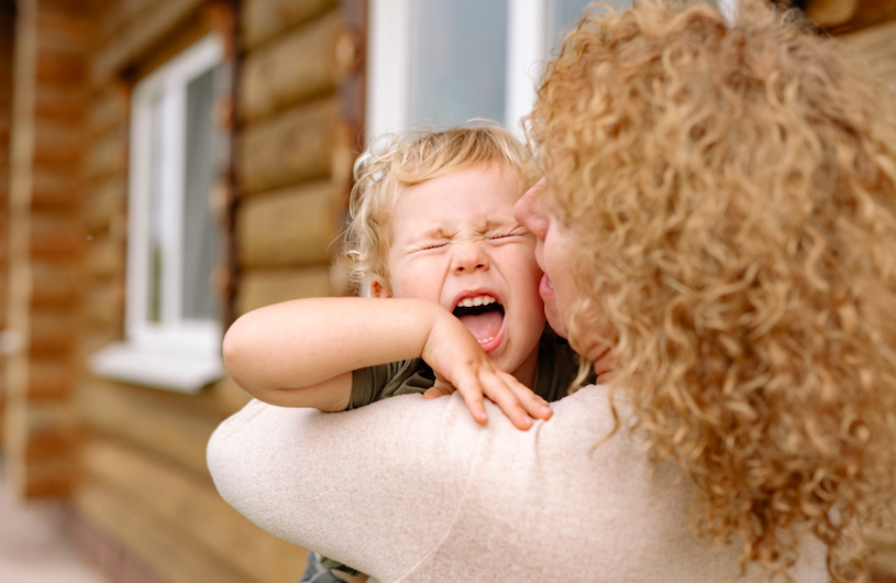 enfant en crise dans les bras de sa maman