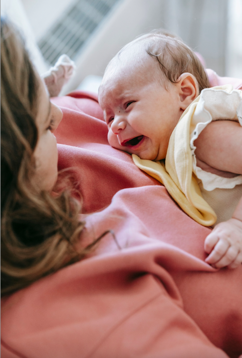 bébé pleure dans les bras de maman